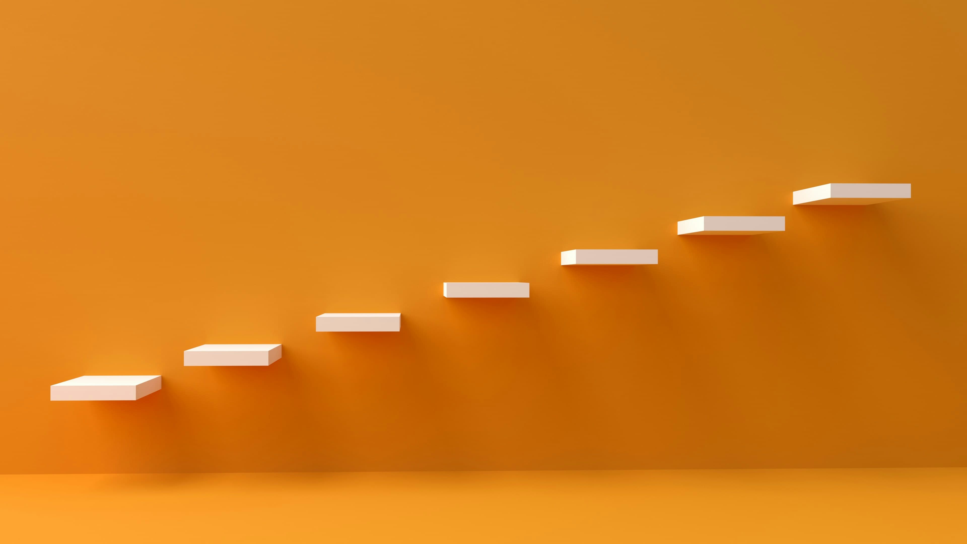 White shelves rising in steps against an orange wall.