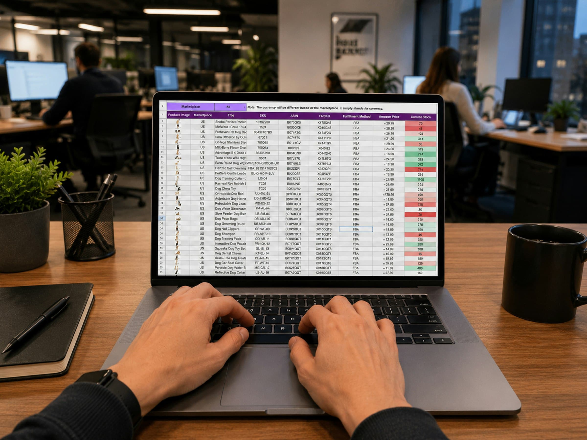 A person typing at a laptop showing a spreadsheet, in an open-plan office.